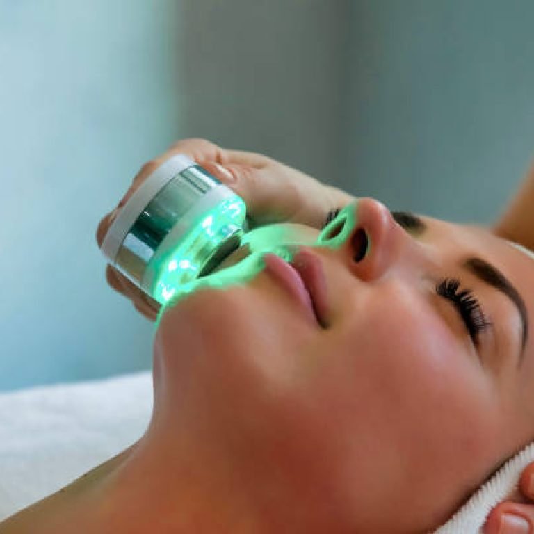 Beautician doing led light therapy to woman in SPA salon, facial phototherapy for skin pore cleaning. Anti-aging treatments and photo rejuvenation procedure. Lady getting face therapy in SPA resort